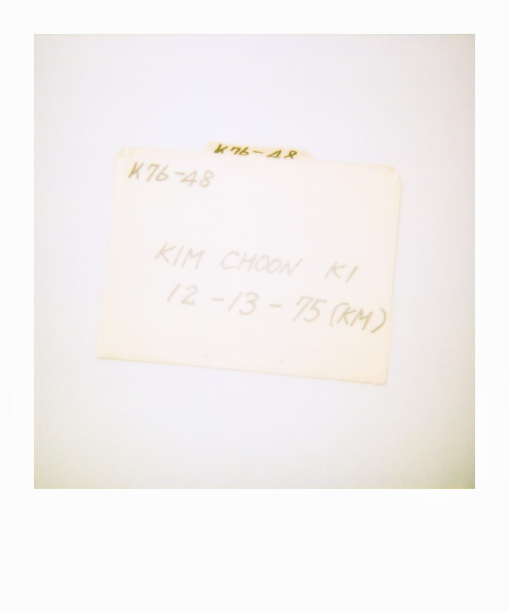 oversized Polaroid of a yellow cardboard folder of an adoption file from Korea